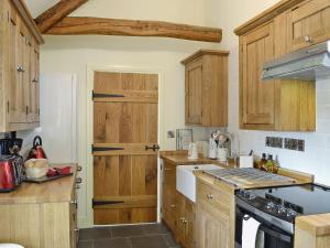 een keuken met houten kasten en een aanrecht bij Nice Home In Wales W- in Strata Florida