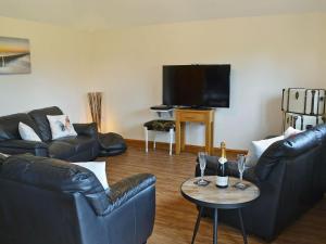 a living room with couches and a table with wine glasses at Mill Stone Cottage - E5423 in Chapel Saint Leonards