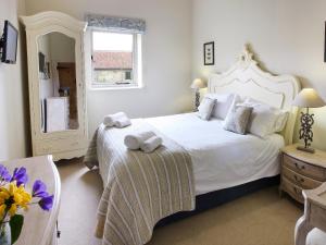 a bedroom with a large white bed with towels on it at Tweedmouth Cottage in Scarborough