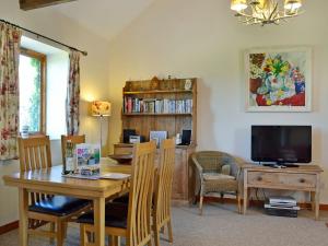 a dining room with a table and a television at The Cart Shed - E1768 in Westleton