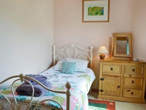 a bedroom with a bed with a dresser and a mirror at The Cart Shed - E1768 in Westleton