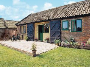 a brick house with a patio in the yard at The Cart Shed - E1768 in Westleton