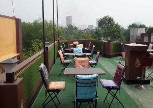 a patio with tables and chairs on a roof at The Kei Inn & Suites Hotel in Kolkata