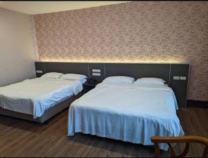 two beds in a hotel room with two beds sidx sidx sidx at 東南亞行旅 in Dajia +4 photos