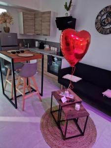 a red heart balloon sitting on a table in a living room at Appartement - Spa in Monteux