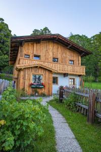 a wooden house with a pathway in front of it at Holzerjuwel - Minzlhof Ramsau am Dachstein in Ramsau am Dachstein