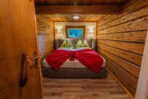 um quarto com uma cama num chalé de madeira em Holzerjuwel - Minzlhof Ramsau am Dachstein em Ramsau am Dachstein