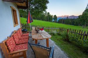 a patio with a table and chairs and an umbrella at Holzerjuwel - Minzlhof Ramsau am Dachstein in Ramsau am Dachstein