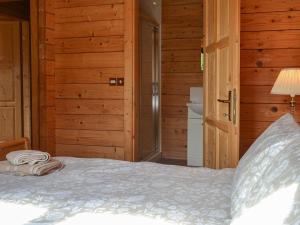 Cama en habitación con paredes de madera en Churn - Uk12536, en Witheridge