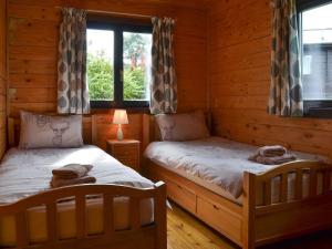 een slaapkamer met 2 bedden in een blokhut bij Churn - Uk12536 in Witheridge
