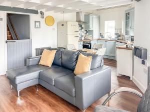 a living room with a couch and a kitchen at The Stables in Penally