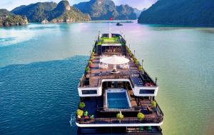 un ferry en un lago con montañas en el fondo en Rita Cruise en Ha Long