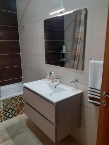 bagno con lavandino e specchio di Cosy Home by the Sea a Birżebbuġa