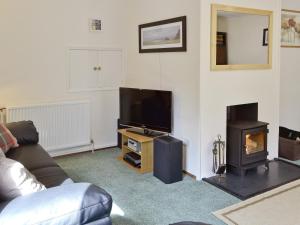 a living room with a couch and a tv and a fireplace at Kilmuir in Selkirk