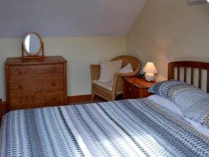 a bedroom with a bed and a dresser and a mirror at Sea Shells in Padstow