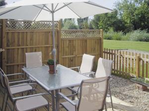 a table and chairs with an umbrella on a patio at Peacock Barn - E5479 in Martin