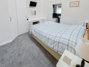 um quarto com uma cama com um cobertor xadrez em Peacock Barn - E5479 em Martin
