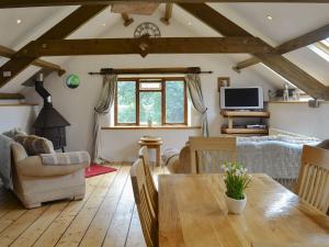 a living room with a wooden table and a tv at The Garden Barn in Ivybridge