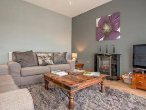 a living room with a couch and a coffee table at Three The Old Stables in Knitsley