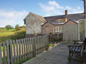 Watermill Cottage في Hargrave: منزل به سياج خشبي وبوابة