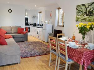 a kitchen and living room with a table and a couch at Tiger in Horsted Keynes
