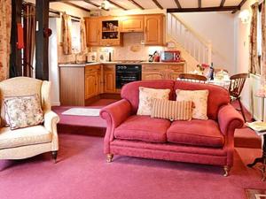 IrebyにあるRose Cottage - Lpdのリビングルーム(赤いソファ付)、キッチン