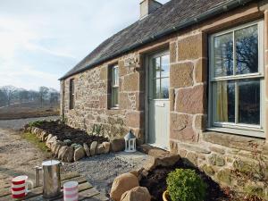 a stone house with a garden in front of it at The Cottage in Bankfoot