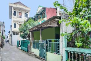 un edificio con una puerta verde en una calle en OYO 92110 Christine Home Stay Syariah, en Pundong