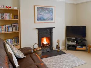 a living room with a couch and a fireplace at Tregatta Terrace in Tintagel