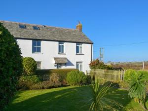 a white house with a fence and a yard at Tregatta Terrace in Tintagel