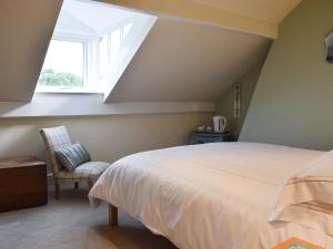 1 dormitorio con cama, ventana y silla en Three Peaks House en Horton in Ribblesdale