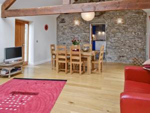 a dining room and living room with a table and chairs at Ty Hir in Aberdaron