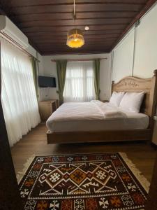 a bedroom with a bed and a rug on the floor at Ziyagil Konağı in Amasya