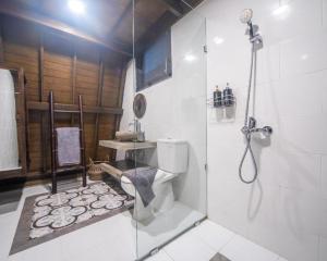 une salle de bain avec une douche, des toilettes et un lavabo dans l'établissement Rumah Kayu Tatiya Villa, à Jimbaran 14 autres photos