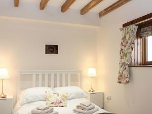 a bedroom with a white bed with towels on it at The Barn in Tickton
