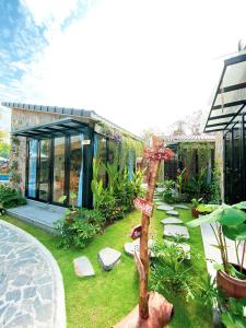 a garden with a wooden cross and a building at Bến Đò Xưa Homestay & Coffee in Cái Răng