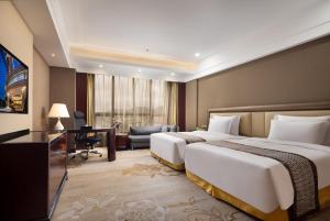 宝安にある深セン バオリライ インターナショナル ホテルのベッド2台とデスクが備わるホテルルームです。