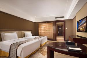 Cette chambre comprend deux lits et un bureau. dans l'établissement Shenzhen Baolilai International Hotel (Baoan, Fuyong), à Bao'an