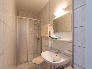 un bagno bianco con lavandino e doccia di Alpengasthof Gruberhof a Söll