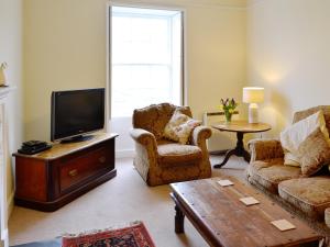 a living room with two chairs and a flat screen tv at Rhydlanfair in Capel Garmon