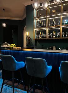 a bar with blue chairs in a room at Hotel Rumor in Budapest