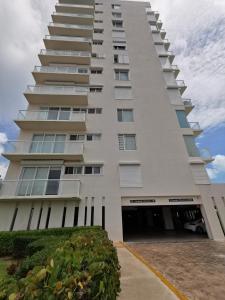 a tall white building with a lot of windows at Pent House amazing View beachfront CANCUN in Cancún