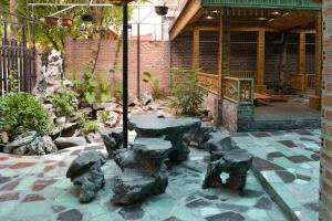 d'une terrasse avec une table et des rochers dans un jardin. dans l'établissement City Garden Hostel, à Ninh Binh