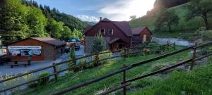 un grupo de edificios en un campo con una valla en U Veselé lišky, en Hutisko