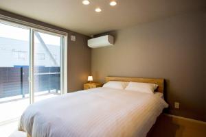 - une chambre avec un grand lit et une grande fenêtre dans l'établissement Rakuten STAY HOUSE x WILL STYLE Matsue 101, à Matsue