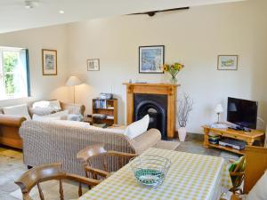 a living room with a couch and a fireplace at La Caleche in Cirencester