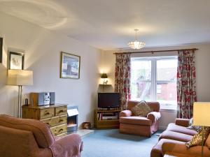 a living room with a couch chair and a tv at Glenrothay in Aviemore