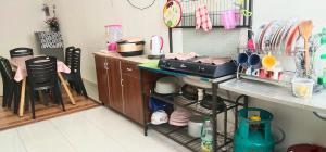 a kitchen with a stove and a counter with dishes at Homestay De'69 in Jitra +24 photos