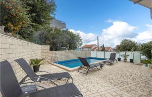 a group of chairs sitting next to a swimming pool at Awesome Home In Crikvenica With House Sea View in Crikvenica