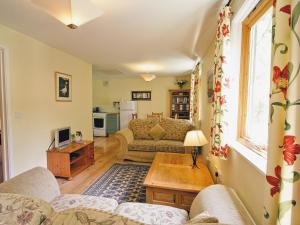 een woonkamer met een bank en een tafel bij Briar Cottage - E5335 in Redisham